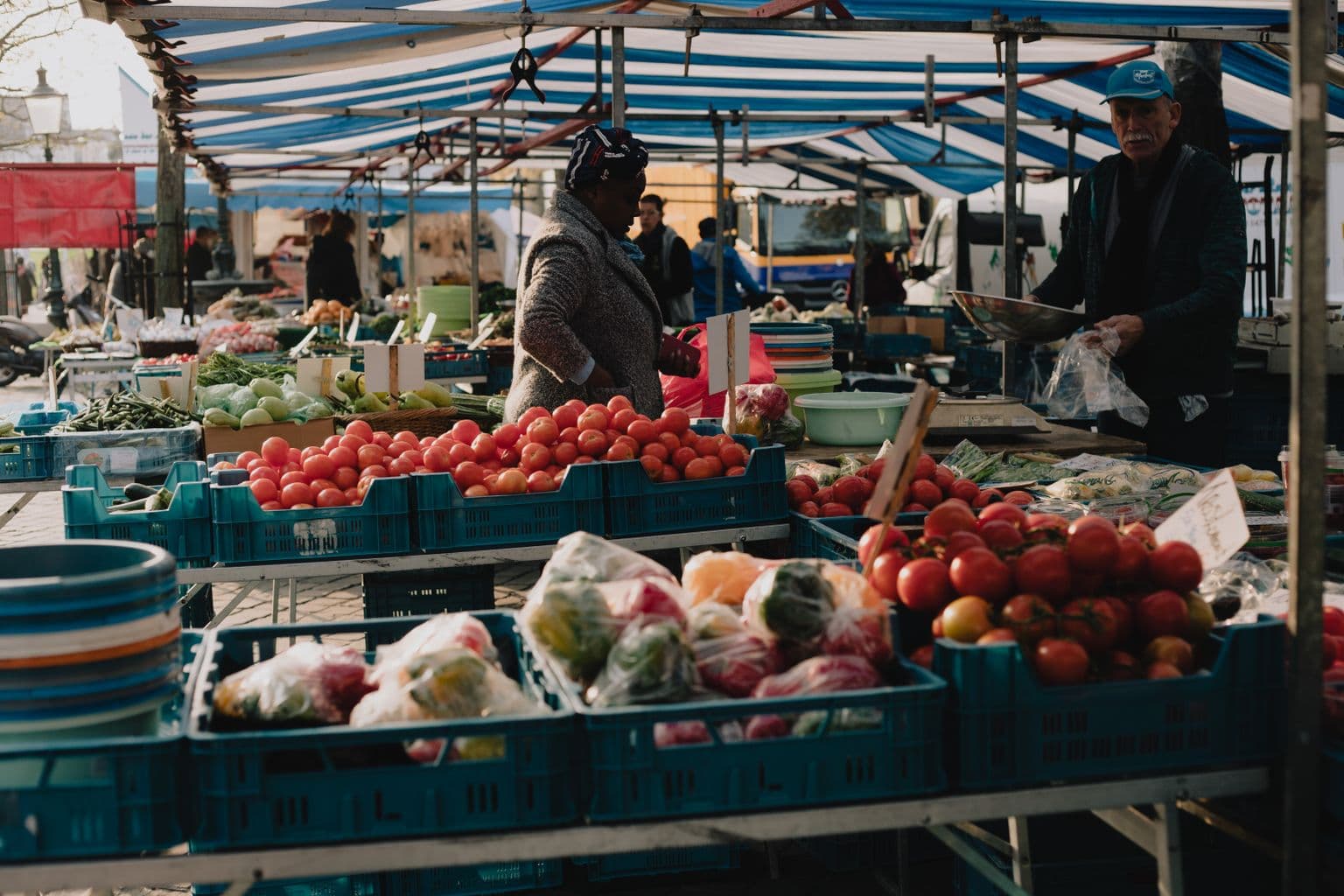 Marktkoopman schept een bestelling voor een klant op de markt in Maastricht