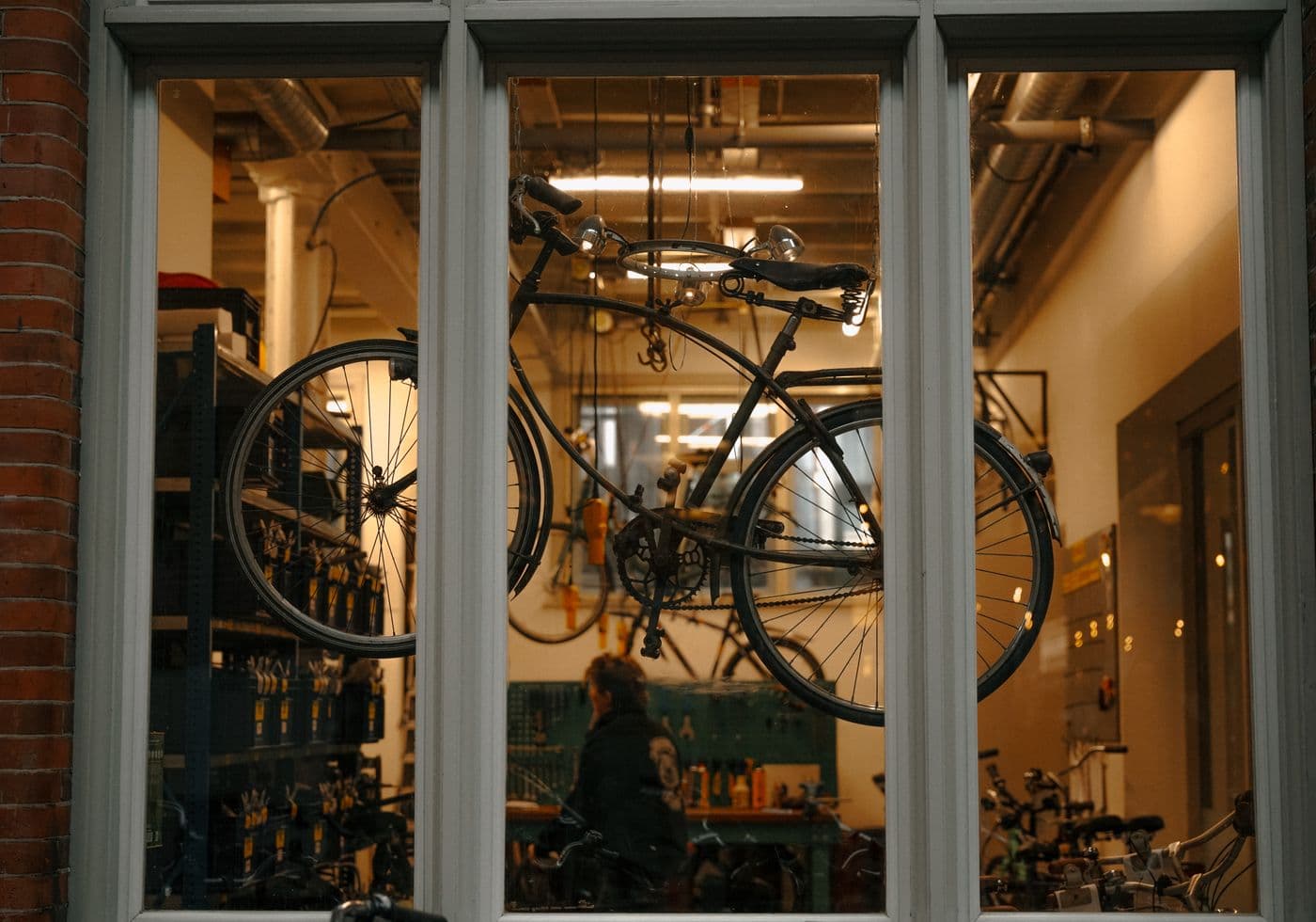 Fietsenwerkplaats met gereedschap en fietsen achter de winkelpui