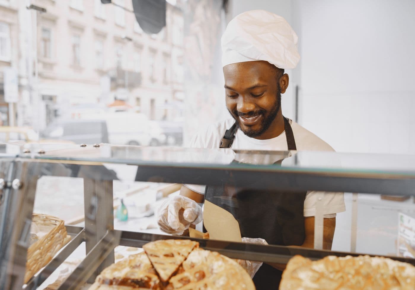 Medewerker van een bakkerij helpt klanten bij de vitrine